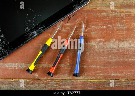 Technician repairing inside of tablet screwdriver in the mobile phone electronic repairing technology. Stock Photo