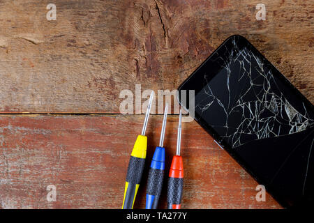 Broken phones on cracked screen Details of the cell phone repair tools Stock Photo