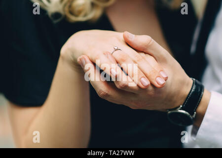 Close up of male and female hands with engagement ring Stock Photo