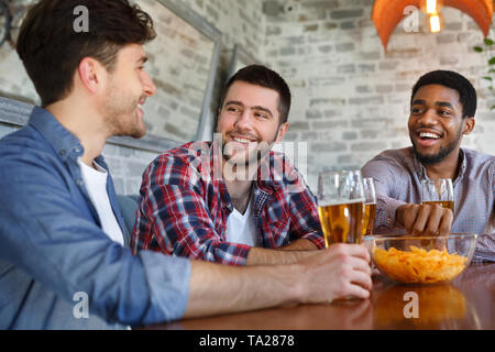 Best Friends Enjoying Beer And Chips, Sitting In Bar Stock Photo
