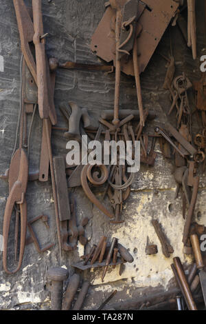 Tools and wrought iron hung in the blacksmith's workshop. Gozo, Malta Stock Photo
