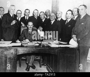 The Hoegner Cabinet, the second  Bavarian post-war Cabinet. Prime Minister and Minister of Justice William Hoegner sits at the table. Standing from left to right: Ludwig Ficker (State Secretary at the Interior Ministry), Albert Rosshaupter (Minister of Labour, SPD), Anton Pfeiffer (Secretary of State, Head of the State, CSU), Johann Ehard (State Secretary at the Ministry of Justice, CSU), Ludwig Erhard (Minister of Economic Affairs, Democratic Party), Josef Seifried (Minister of the Interior, SPD), Franz Fendt (Minister of Education, SPD), Fritz Terhalle (Minister of Finance, independent), Stock Photo