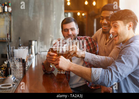 Male Friends Drinking Beer And Talking In Bar Stock Photo