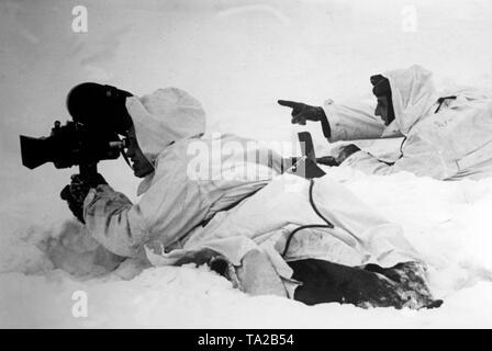 Two camouflaged German film reporters film in the snow on the Eastern Front. Photo of the Propaganda Company (PK): war correspondent Gebauer Stock Photo
