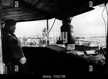 A soldier takes over the observation of the airspace from a fire tower. The unknown small town is located a few kilometers behind the front line. Photo of the Propaganda Company (PK): war correspondent Knirsch. Stock Photo