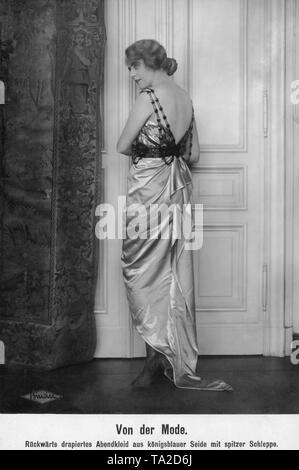 Mady Christians, a German actress, in an evening dress made of royal blue silk with peaked train, which is draped in the back and is low-backed. Stock Photo