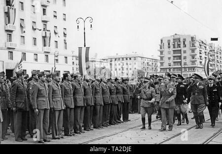 Italian soldiers returning to Italy, who fought as volunteers on the side of the Franco troops in the Spanish Civil War, are received by Victor Emanuel III of Italy (salutes with a peaked cap) and other high-ranking officers in the port of Genoa on June 15, 1939. Stock Photo