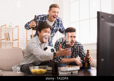 Soccer Fans Emotionally Watching Game In Living Room Stock Photo