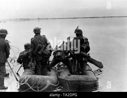 Soldiers of a German advance department cross the Dnieper. The soldier right in the picture is armed with an Mp-40. Stock Photo