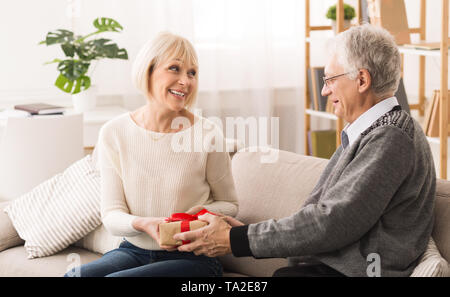 Loving Husband Making Surprise To Amazed Wife Stock Photo