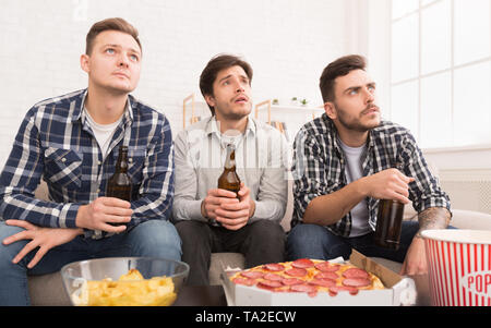 Upset Friends Watching Football Game At Home Stock Photo