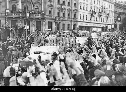 Adolf Hitler entering Karlsbad (today Karlovy Vary) on October 4, 1938. His motorcade is received cheerfully by the population. They are greeting him the Nazi salute. In his car in the back on the right, Adjutant of the Luftwaffe Nicolaus von Below. Sitting in front of him, General Walter von Reichenau. The bodyguards of the SS follow with other cars. Stock Photo