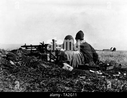 German soldiers with a heavy machine gun 34 at a fighting station on the Mius-Front. They watch their comrades a few meters away in the field. Photo of the Propaganda Company (PK): War correspondent Mentz. Stock Photo