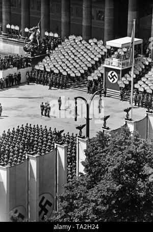 Flag command of the Condor Legion (with the troop banner, Spanish: bandera) standing in front of the lectern in the Berlin Lustgarten during the speech of Adolf Hitler (under canopy with swastika). In front of it stands the commander Major General Wolfram Freiherr von Richthofen. Behind them soldiers of a guard regiment, Hitler Youth members holding the signs with the names of the fallen and the facade of the Altes Museum. Stock Photo