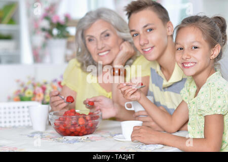 Portrait of big happy family eating fresh strawberries Stock Photo