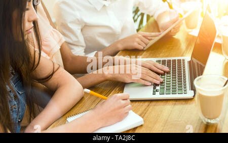 Woman typing on her laptop and colleague write the task Stock Photo