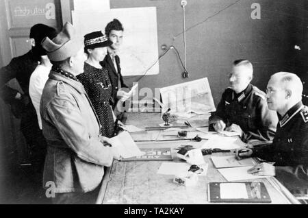 In the German local headquarters in Luneville an Unteroffizer and a Wehrmacht official (left) register released French war prisoners. Photo: Hochscheid Stock Photo