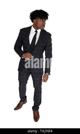 An African American young man standing in a suit and white shirt and tie relaxes in the studio, isolated for white background Stock Photo