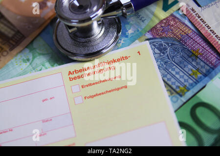 VIERSEN, GERMANY - MAY 20. 2019: Inability to work cost concept - Stethoscope and yellow certificate of incapicity (German: Arbeitsunfähigkeitsbeschei Stock Photo