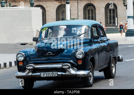 Havana, Cuba - 25 July 2018: A blue classic 1050s car being used as a taxi driving tourists around Old Havana City Cuba. Stock Photo