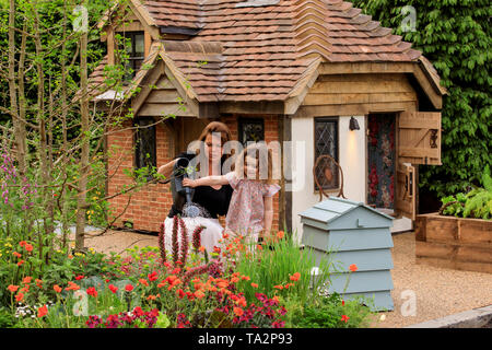 Rose Charlton age 4, from Hampshire, pictured adding the finished touches to the garden in front of a cottage playhouse this morning at RHS Chelsea Flower Show. Two beautiful bespoke playhouses are Rose Charlton age 4, from Hampshire, pictured adding the finished touches to the garden in front of a cottage playhouse this morning at RHS Chelsea Flower Show. Two beautiful bespoke playhouses are