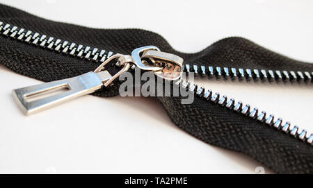 black metal open zipper closeup isolated on white background macro Stock Photo