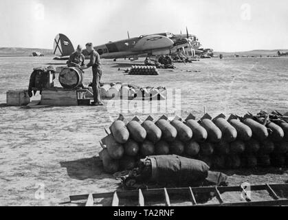 Photo of German Heinkel He 111 fighter bombers of the Condor Legion (Bomber group K / 88) on the airfield of Lerida, Catalonia, 1939. In the foreground there are grenades. Behind, ground personnel are working. The Saint Andrew's Cross of the Spanish Air Force is visible on the vertical tail. Stock Photo