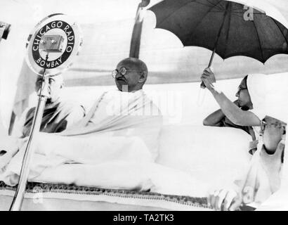 Mahatma Gandhi opens the All India Swadesi exhibition in Vithalnagar, Huripura. There takes place the 51st Indian National Congress. Behind him sits his secretary Madeleine Slade, Mirabehn, holding a sunshade over his head. Stock Photo