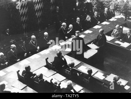During the first council meeting in the small meeting room of the Munich Town Hall, the Lord Mayor Karl Scharnagl, who was appointed by the Allies, hands over letters of appointments to the 36 city councilmen. Stock Photo
