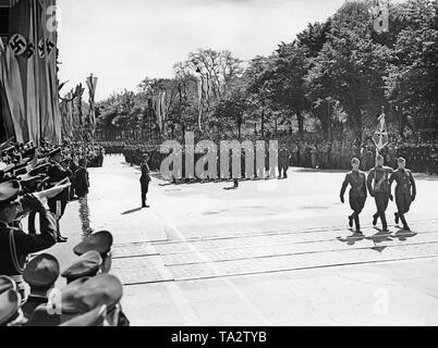 Photo of a unit of the Condor Legion marching in front of Field Marshal General Hermann Goering (on the right with general's baton, chief commander of the Luftwaffe) at Karl Muck Platz (today Johannes Brahms Platz) in Neustadt, Hamburg. In the front, color guards, two officers and a corporal with the regimental standard are parading. Stock Photo