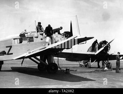 Student pilots and ground personnel of the Luftwaffe during the refueling of a Junkers W 34, this plane type was frequently used by the Luftwaffe as a school engine. Stock Photo