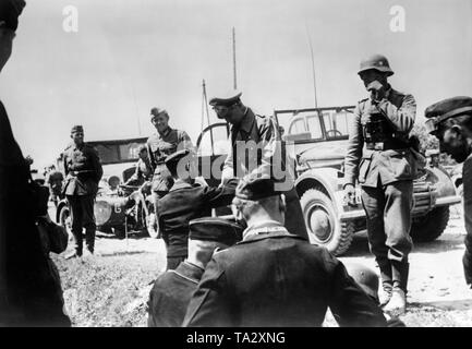 Division commander, Lieutenant General Hermann Meyer-Rabingen (standing, 2nd from right) at a commander's meeting. In the background several vehicles of the Wehrmacht. Photo: war correspondent Lucke. Stock Photo