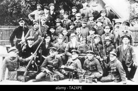 Soldiers of a Freikorps unit pose during the first Polish uprising in Upper Silesia with their Gewehr 98 guns and a machine gun. On the ammunition boxes in the foreground swastikas were painted as an expression of their political conviction. In the second row from below in the middle with white hat is the later SA leader Edmund Heines. Stock Photo