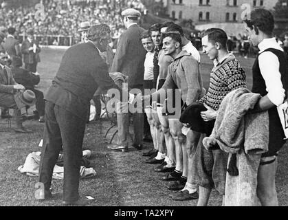 The German cyclist Walter Ruett congratulates the participants of an amateur race on the newly opened Ruettbahn in the Berlin Polizeistadion. Stock Photo