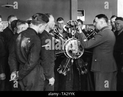Student pilots of the Luftwaffe have a lesson at the cutaway model of an aircraft engine in order to study its structure and mode of operation. Stock Photo