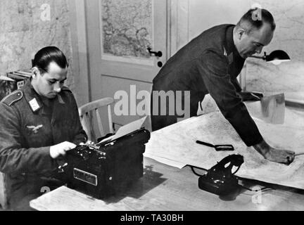 The staff officer of an army group dictates the military situation and the results of the reconnaissance to the typist. Photo: war correspondent Standartenfuehrer Seuffert. Stock Photo