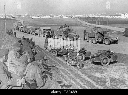 An antiaircraft battery of the German Condor Legion takes rest on a road at Toledo during the last battles of the Spanish Civil War on March 28, 1939. On the right in the foreground, Kradschuetze (motorcycle mounted infantrymen) are having a rest. Their motorcycles of the type BMW R12 (partly with sidecar) are parked on the roadside. Behind, a convoy of trucks of the type Krupp L2 H143. Stock Photo