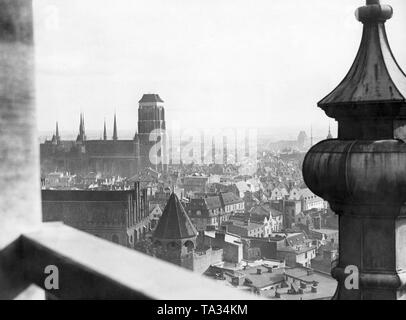 This photograph shows the view from St. Catherine's Church on St. Mary's Church. St. Catherine's Church is one of the oldest churches in Gdansk and was probably built at the end of the 19th century. The groundbreaking ceremony of St. Mary's Church took place in 1343 and the church was completed in 1502. It was built in Brick Gothic style. It is one of the largest brick churches north of the Alps and has place for 25,000 people inside. It houses the famous triptych 'The Last Judgment' by the painter Hans Memling. Stock Photo