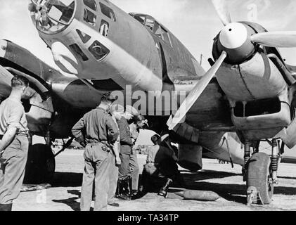 Photo of a two-engine Heinkel He 111  bomber during the placement of bombs by ground personnel on a Spanish airfield in 1939. In the upper edge of the photo, the forward gunner compartment, which was made of plexiglass. Stock Photo