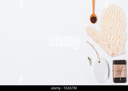 Body care products and accessories on white background, top view. Stylish flat lay arrangement of rough mitten washcloth, coffee scrub, soap and pumic Stock Photo