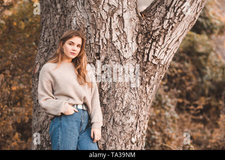 Beautiful teen girl 16-17 year old wearing stylish clothes posing outdoors. Lookng at camera. 20s. Stock Photo