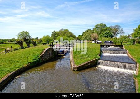 A narrow canal boat passing through Papercourt lock on the River Wey Navigation at Ripley Surrey England UK Stock Photo