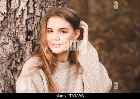 Smiling blonde teen girl 14-16 year old wearing stylish clothes posing  outdoors. Looking at camera. Autumn season Stock Photo - Alamy