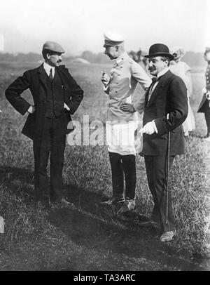 Crown Prince Wilhelm (middle) arrived, together with his wife Crown Princess Cecilie of Prussia born Duchess of Mecklenburg, (2nd from right), to the airfield Tempelhof Field to follow the flight demonstration of Orville Wright (left). Here, the Crown Prince having a conversation with the famous aviator. Stock Photo