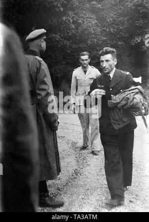 A French lieutenant (in the front) and a sergeant (bright uniform) fall into German war captivity. They were shot down by a German fighter, but were able to survive with the help of a parachute. Photo: war correspondent Rehor. Stock Photo