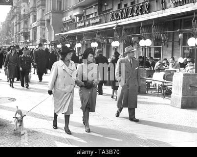 Strollers at the Kurfuerstendamm in front of Cafe Kranzler, Easter 1942. The first Cafe Kranzler in Berlin was opened in 1825 by Johann Georg Kranzler as a small pastry shop in the street 'Unter den Linden' in Berlin Mitte. In 1932 he opened the second branch in the former Cafe des Westens under the name 'Restaurant und Konditorei Kranzler' in the Joachimstaler Strasse (today Joachimsthaler Strasse) in the district Charlottenburg. Both buildings were destroyed during air raids in the years 1944 and 1945. Stock Photo