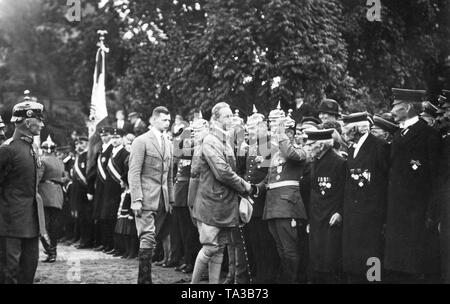 The German Crown Prince (3rd from the left) takes the salute of soldiers and veterans, whom he shakes hands with. Behind Crown Prince Wilhelm is his son, Prince William of Prussia (2nd from left). Stock Photo