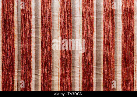 red vertical striped synthetic woven upholstery fabric close-up texture and background Stock Photo