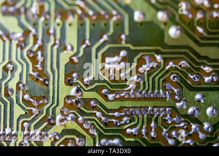 back side of two-layered green analog pcb without components selective focus background Stock Photo