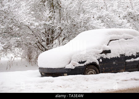 Old dirty car covered by thick snow layer with selective focus. Stock Photo